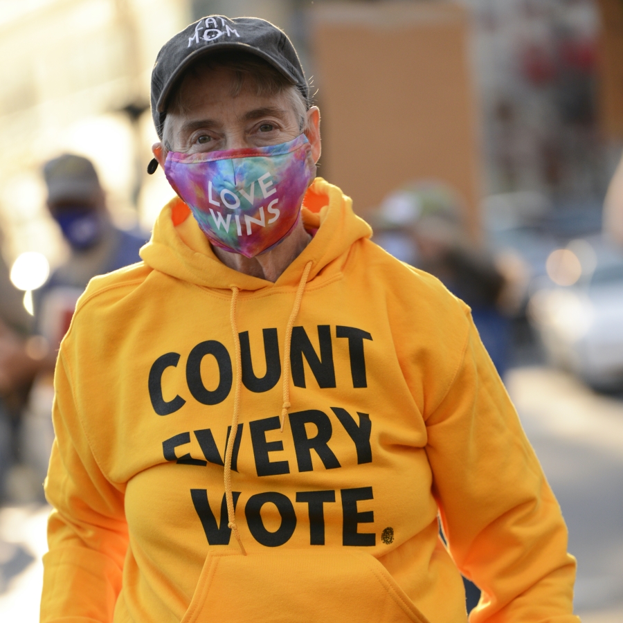 Man with facemask and hooded jacket that reads "Count Evey Vote"